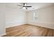 The bedroom features vinyl floors, a ceiling fan, and a window offering ample natural light at 5151 Martins Crossing Rd, Stone Mountain, GA 30088