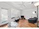 Bright living room featuring large windows with blinds, a cozy chair, and hardwood flooring at 1575 Ridenour Nw Pkwy # 820, Kennesaw, GA 30152