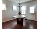 Bright dining area with hardwood floors, a round table with modern design, and natural light from the windows at 221 Begonia Way, Mcdonough, GA 30253