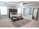 Spacious main bedroom with large rug, tufted headboard, and plenty of natural light at 221 Begonia Way, Mcdonough, GA 30253