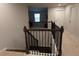 View of carpeted staircase with dark wood and black wrought iron railing at 221 Begonia Way, Mcdonough, GA 30253