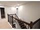 View of carpeted staircase with dark wood and black wrought iron railing at 221 Begonia Way, Mcdonough, GA 30253