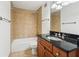 Bathroom featuring a tile surround shower-tub, dark granite counters, and wood cabinetry at 2479 Peachtree Ne Rd # 1703, Atlanta, GA 30305