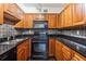 A traditionally styled kitchen with wood cabinets and black appliances at 2479 Peachtree Ne Rd # 1703, Atlanta, GA 30305