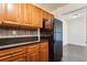 Galley kitchen with wood cabinets and black refrigerator at 2479 Peachtree Ne Rd # 1703, Atlanta, GA 30305