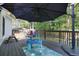 View of the outdoor deck featuring shade umbrella, ' water table, and wooded lot at 3003 Maple Ln, Alpharetta, GA 30009