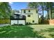 View of home's backyard with deck, patio and fenced-in lawn with mature trees at 3003 Maple Ln, Alpharetta, GA 30009