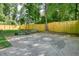 View of basketball court in backyard surrounded by wood fence and green trees at 3003 Maple Ln, Alpharetta, GA 30009