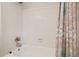 Bright white tiled bathtub with a colorful patterned shower curtain at 3003 Maple Ln, Alpharetta, GA 30009