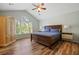 Charming bedroom featuring vaulted ceiling, ceiling fan, wood-look floors and a large window at 3003 Maple Ln, Alpharetta, GA 30009