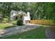 Home featuring a spacious driveway, fenced yard, and traditional exterior architecture at 3003 Maple Ln, Alpharetta, GA 30009