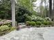 Serene backyard patio features lush greenery, flowering plants, and a quaint wooden bench for relaxation at 366 Blackland Nw Rd, Atlanta, GA 30342
