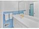 The bathroom has a vintage design with blue tiling, white cabinets, and gold fixtures at 366 Blackland Nw Rd, Atlanta, GA 30342