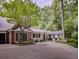 Traditional-style home with a well-maintained driveway, lush landscaping, and a brick accent under a beautiful tree at 366 Blackland Nw Rd, Atlanta, GA 30342