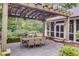 Outdoor dining area with a wooden pergola, dining table, and a stone-paved patio perfect for entertaining at 366 Blackland Nw Rd, Atlanta, GA 30342