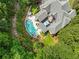 Aerial view of luxury home showcasing a sparkling pool, a spa, and an outdoor entertainment area amidst lush landscaping at 10275 Worthington Mnr, Suwanee, GA 30024