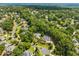 Picturesque aerial shot showcases the tranquil neighborhood with lush trees surrounding gorgeous luxury homes at 10275 Worthington Mnr, Suwanee, GA 30024