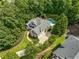 Aerial view of a stunning home featuring lush landscaping, an outdoor pool, and expansive patio for entertaining at 10275 Worthington Mnr, Suwanee, GA 30024