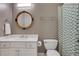 Bathroom featuring a white vanity and sink with a rattan framed round mirror at 10275 Worthington Mnr, Suwanee, GA 30024