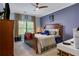 Bedroom featuring a ceiling fan and a large window with wood shutters at 10275 Worthington Mnr, Suwanee, GA 30024