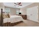 Cozy bedroom with neutral tones, featuring a ceiling fan, carpet, and window with plantation shutters at 10275 Worthington Mnr, Suwanee, GA 30024