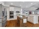 A kitchen features an island, stainless steel appliances, and white cabinets at 10275 Worthington Mnr, Suwanee, GA 30024