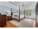 A main bedroom features a tray ceiling, a ceiling fan, and large windows at 10275 Worthington Mnr, Suwanee, GA 30024