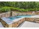 Luxurious backyard with a pool, hot tub, and waterfall feature at 10275 Worthington Mnr, Suwanee, GA 30024