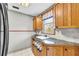 Bright kitchen with wooden cabinets, stainless steel sink, and mosaic tile backsplash under a window at 1315 Woodland Sw Dr, Oxford, GA 30054