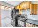 Open kitchen showcases black fridge, stove, and wood cabinets, with a view into the living room at 1315 Woodland Sw Dr, Oxford, GA 30054