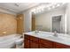 Bathroom featuring double sink vanity, bathtub, and updated tile surround at 2251 Limehurst Ne Dr, Atlanta, GA 30319