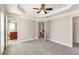 Bright bedroom with bathroom access, a ceiling fan, and tray ceiling details at 2251 Limehurst Ne Dr, Atlanta, GA 30319