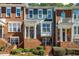 Elegant townhome displaying a brick front, unique trim color, covered porch, and manicured shrubs at 2251 Limehurst Ne Dr, Atlanta, GA 30319