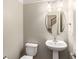 Simple powder room with pedestal sink, oval mirror, and lighting fixture at 2251 Limehurst Ne Dr, Atlanta, GA 30319