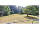 Spacious backyard surrounded by mature trees with a chain-link fence at 3868 Demooney Rd, Atlanta, GA 30349