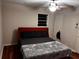 Modern bedroom featuring a red headboard, dark linens, and a ceiling fan at 3868 Demooney Rd, Atlanta, GA 30349