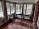 Sunroom filled with natural light through multiple windows showcasing wood floors and massage table at 3868 Demooney Rd, Atlanta, GA 30349