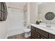 Neutral bathroom with tub shower, brown vanity, and decor at 590 Palm Springs Cir, Fairburn, GA 30213