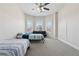 Comfortable bedroom with beds underneath a ceiling fan and large windows at 590 Palm Springs Cir, Fairburn, GA 30213