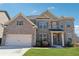 Beautiful brick two-story home with attached two-car garage and manicured lawn on a sunny day at 590 Palm Springs Cir, Fairburn, GA 30213