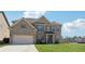 Beautiful brick two-story home with attached two-car garage and manicured lawn on a sunny day at 590 Palm Springs Cir, Fairburn, GA 30213