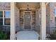 Close up of the home's front entryway with stone accents, gray door, and white columns at 590 Palm Springs Cir, Fairburn, GA 30213