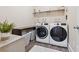 Well-organized laundry room with modern washer and dryer, shelving, and storage baskets at 590 Palm Springs Cir, Fairburn, GA 30213