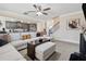 Spacious living room featuring a modern sectional sofa, fireplace, and ceiling fan at 590 Palm Springs Cir, Fairburn, GA 30213