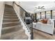 Staircase leading to a living room with a fireplace, a ceiling fan, and a plush sectional at 590 Palm Springs Cir, Fairburn, GA 30213