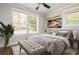 A well-lit bedroom with a ceiling fan and a large bed with a tufted bench and green pillows at 2542 Warwick Ne Cir, Atlanta, GA 30345