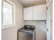 Laundry room featuring a front loading washer below upper cabinets, and a window at 2542 Warwick Ne Cir, Atlanta, GA 30345