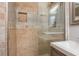 Shower with glass enclosure, tile surround, shelving, and a chrome shower head and handle at 2542 Warwick Ne Cir, Atlanta, GA 30345