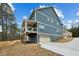 Two-story home with blue siding, a covered deck with a ceiling fan, and a two-car garage on a concrete driveway at 3119 Stonegate Sw Dr, Atlanta, GA 30331