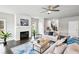 Spacious living room with fireplace, fan, hardwood floors, and large windows at 3119 Stonegate Sw Dr, Atlanta, GA 30331